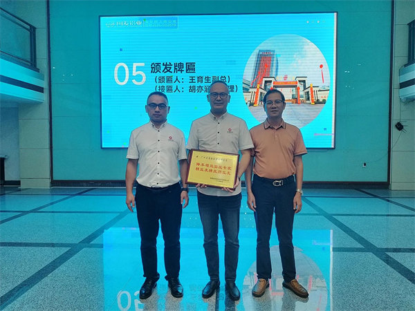 閩發鋁業生產中心副總經理王育生先生(右)向正睿咨詢集團頒發牌匾 閩發鋁業生產中心副總經理王育生先生(右)向正睿咨詢集團頒發牌匾